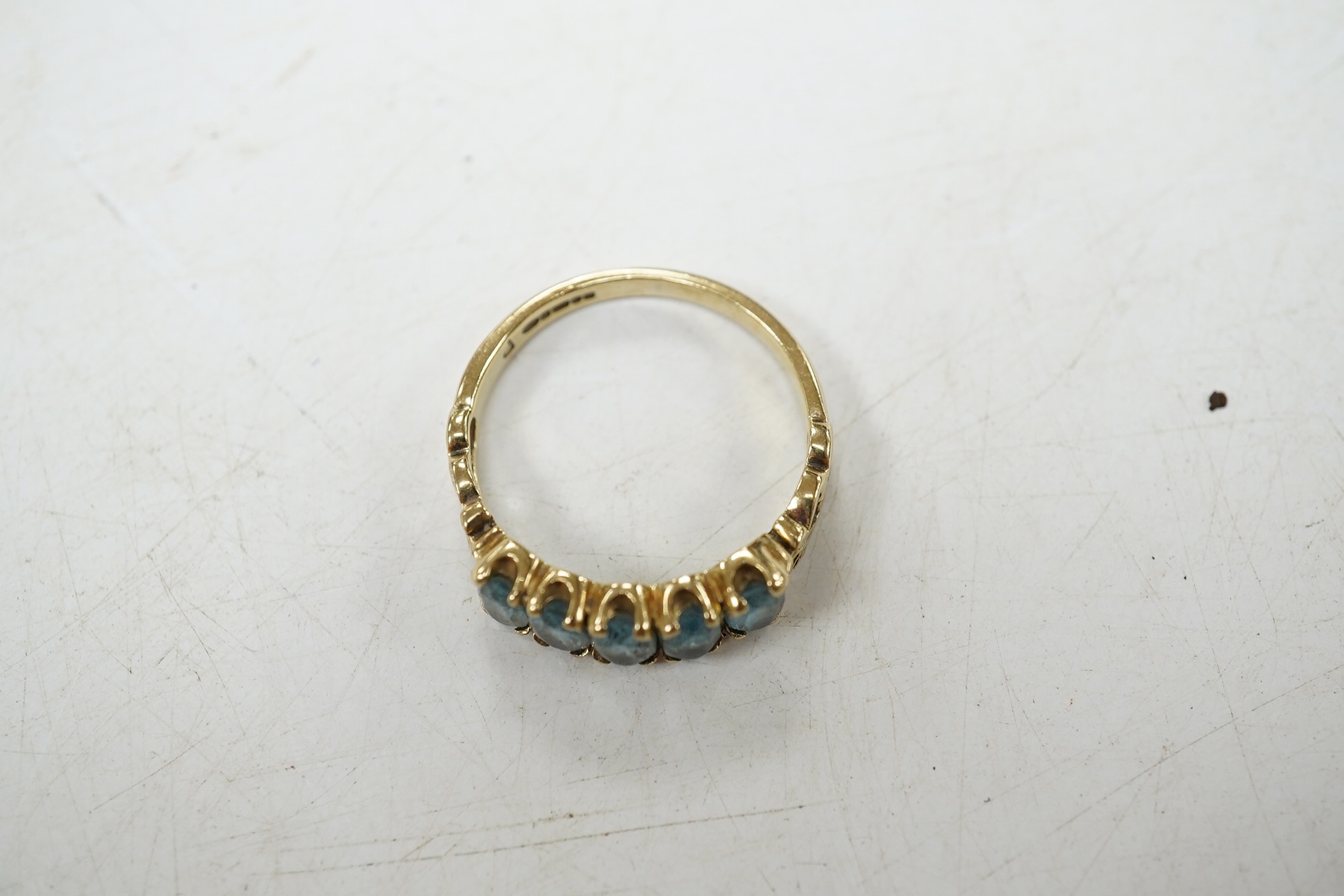 A modern 9ct gold and five stone oval cut blue topaz set half hoop ring, size N/O, gross weight 2.7 grams. Condition - poor to fair